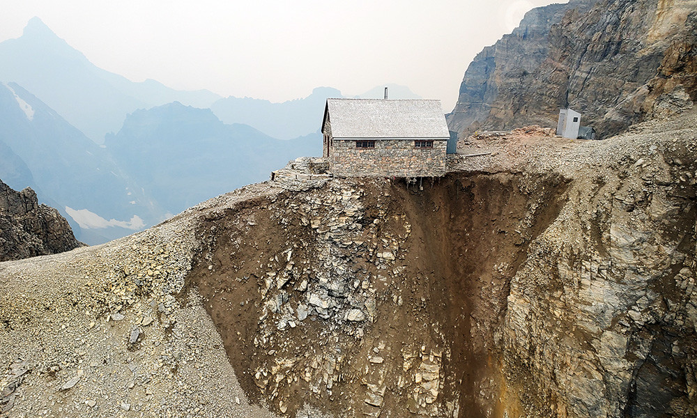 Abott Pass Hut sitting precariously on the mountain, with the ground falling away beneath it